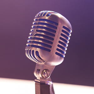 Image of microphone with purple background and blue lighting.