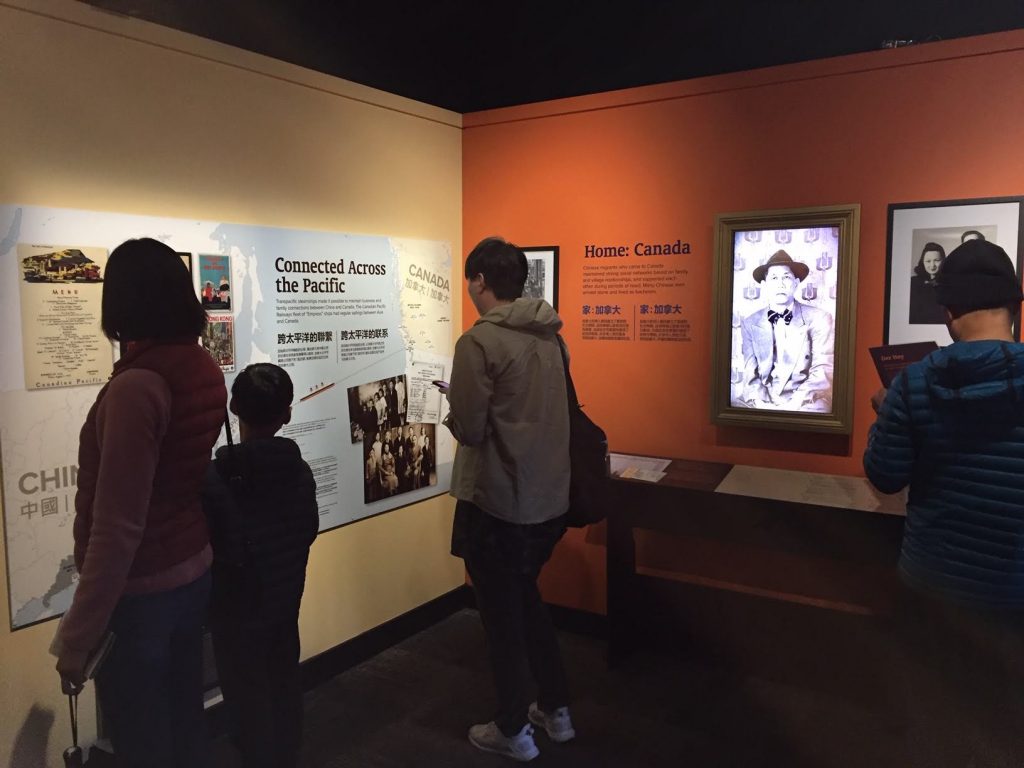 Individuals attending the "Across the Pacific" exhibit at the Burnaby Village Museum.